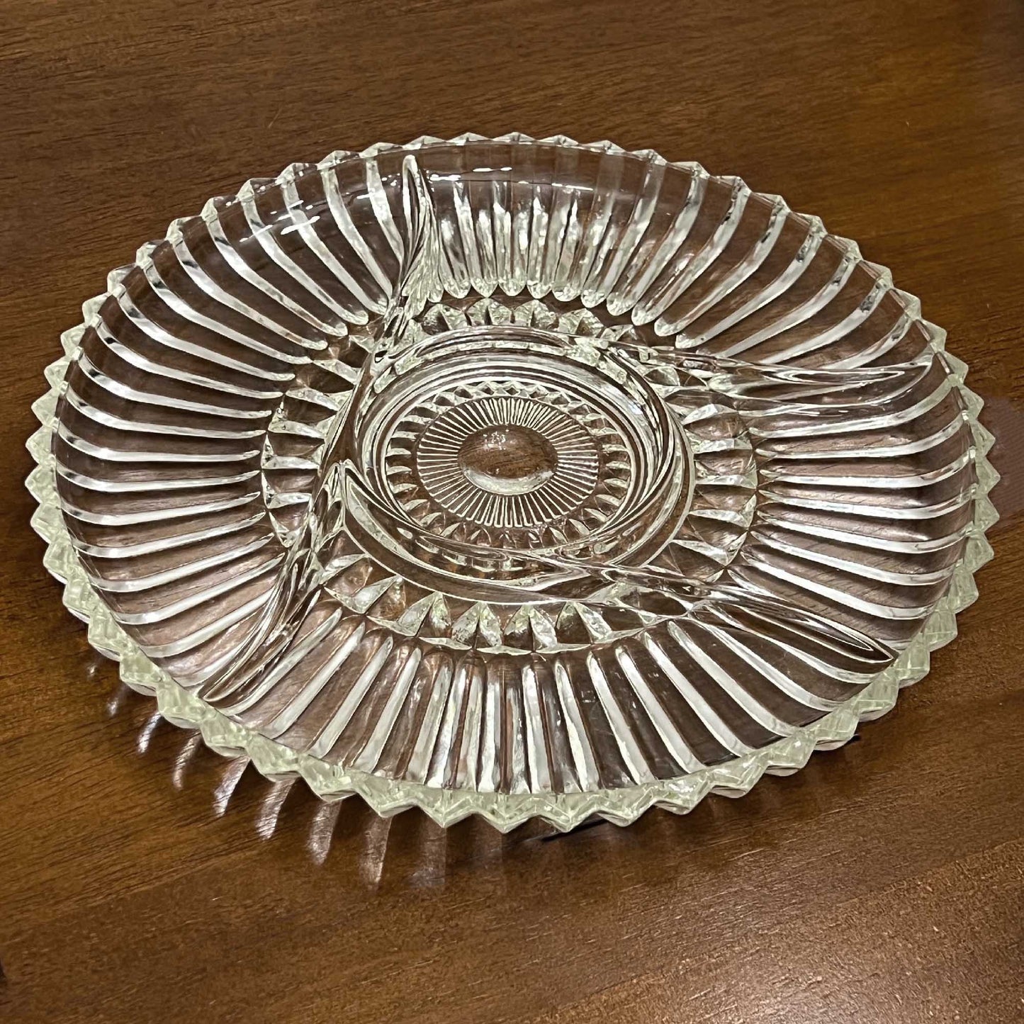 Clear glass dish with decorative pattern on a wooden surface