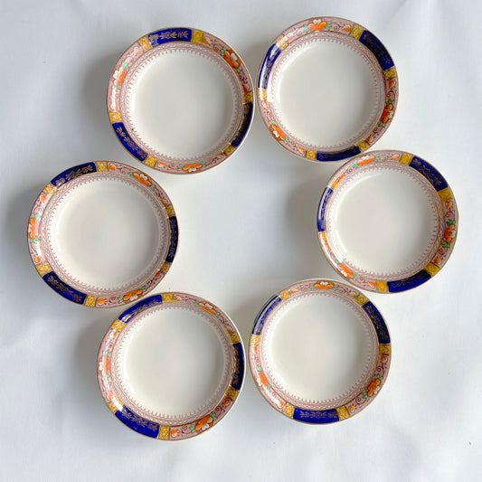 Set of six ceramic plates with decorative borders on a white background