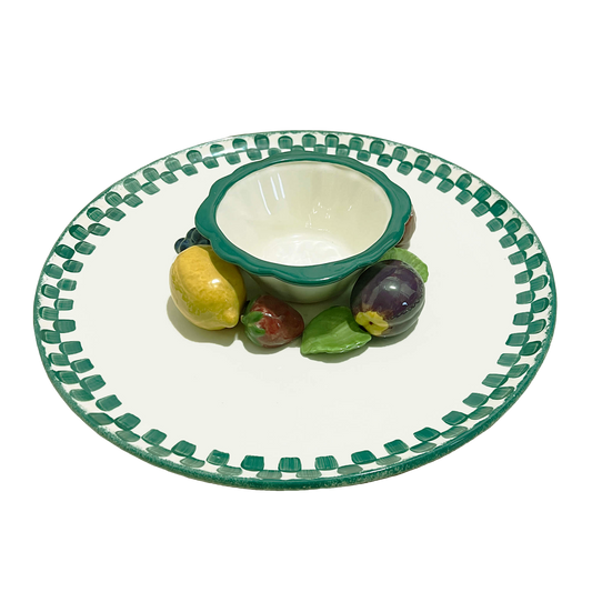 Ceramic plate with green rim and decorative edge, featuring a small bowl and fruit figurines on a white background.