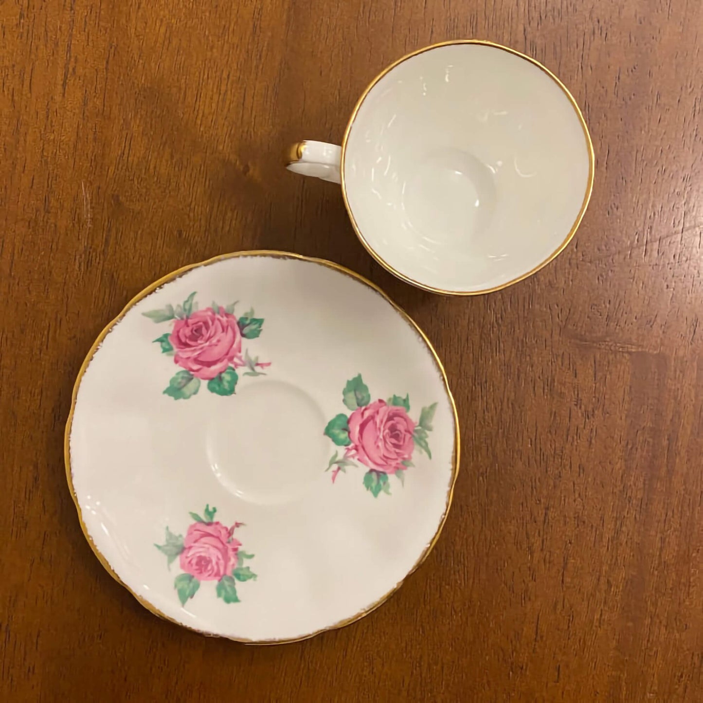 Jason-bone-china-collectible-teacup-and-saucer-set,-#J554,-featuring-pink-roses-and-green-leaves,-accented-by-gilt-trim-on-the-edge-of-the-cup-and-saucer.-Excellent-condition.-Makes-a-great-gift.-Shop-eBargainsAndDeals.com.