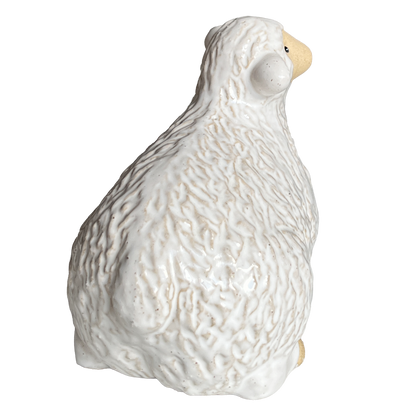 White ceramic sheep figurine view from the back.