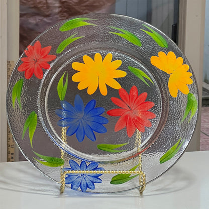 Decorative glass plate with colorful flowers on a stand