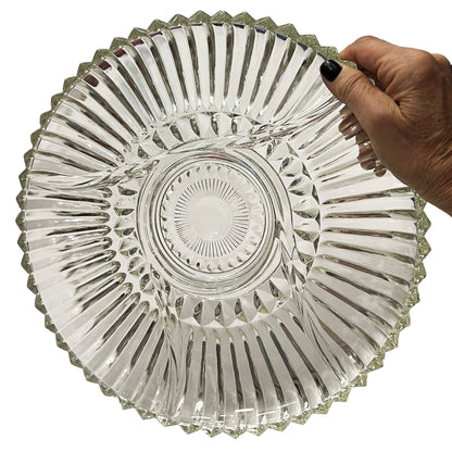 Clear glass dish held by a hand on a white background