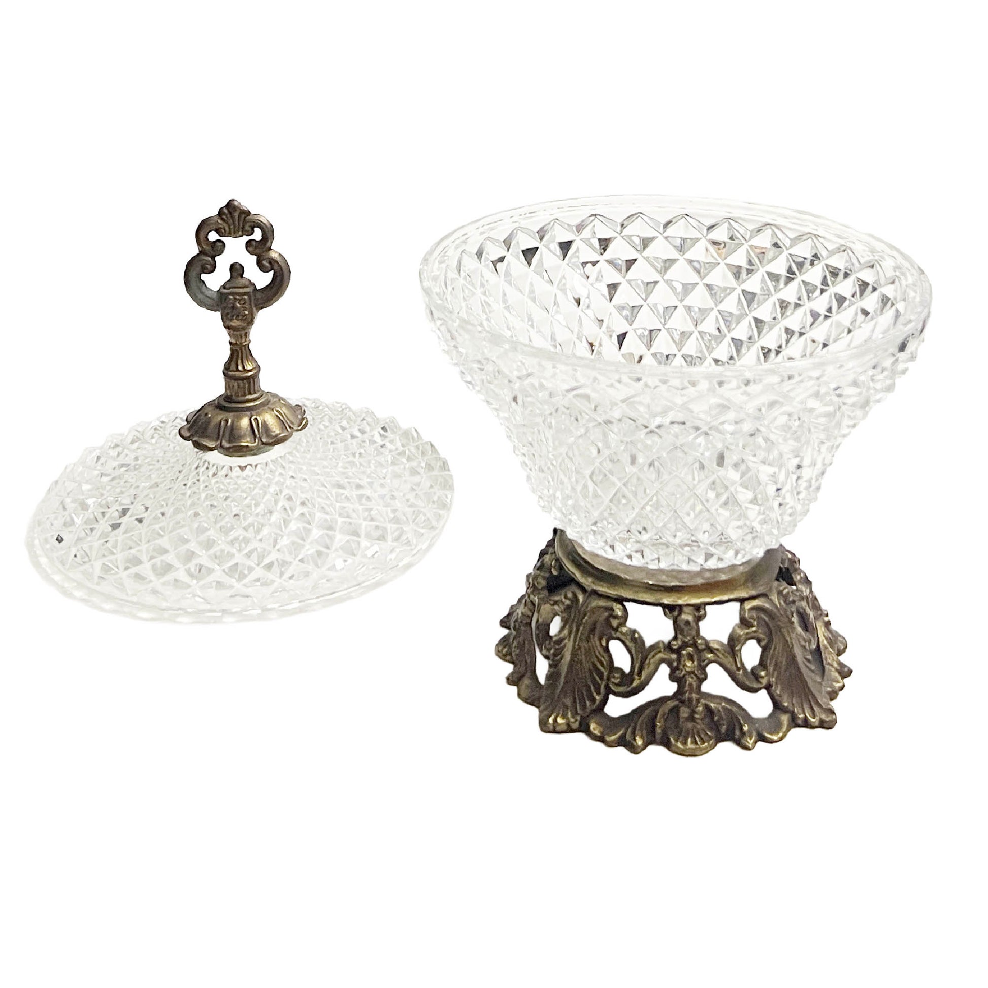 Clear cut glass bowl design on a decorative metal stand against a white background