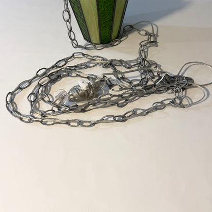 Metal chain with a decorative element on a white surface