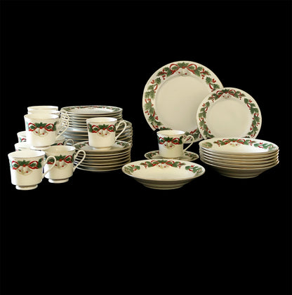 Set of Royal Majestic "Noel" dinnerware with festive holly and berry design.on a black background
