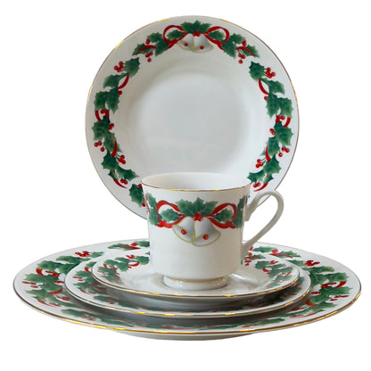 Christmas-themed teacup and saucers with holly design on a white background
