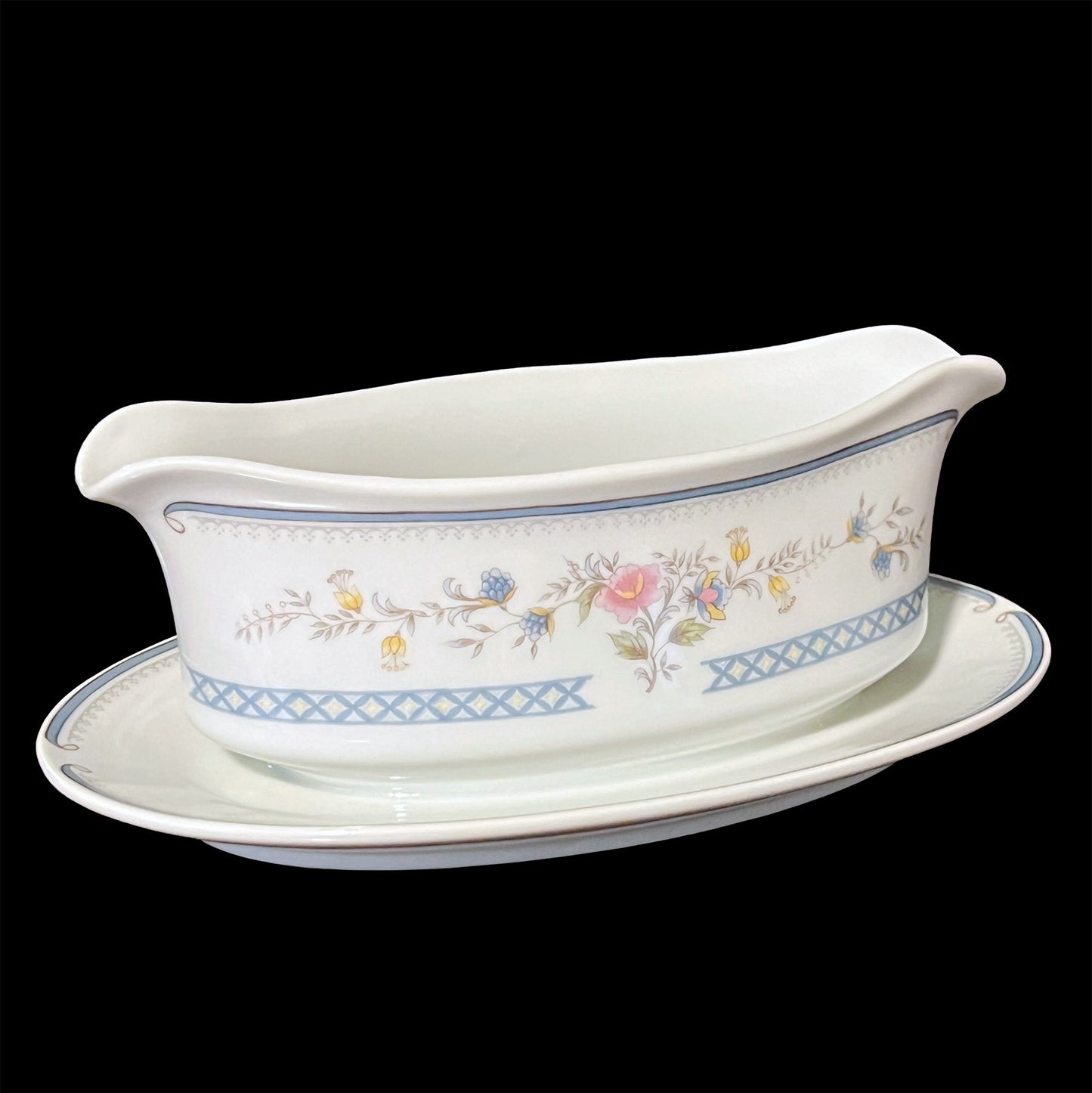 Side view of Brookwood M1012 gravy boat showing handle and spout with colorful flower pattern on white porcelain