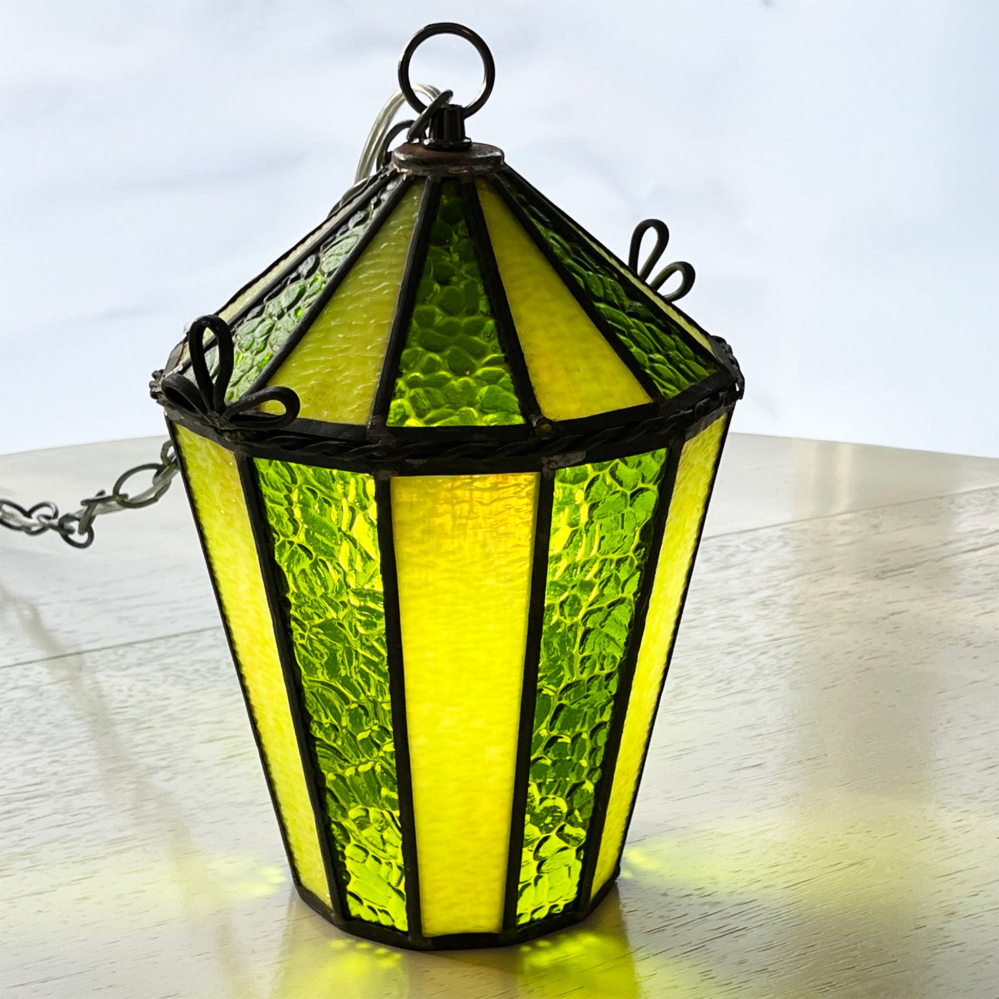 Green stained glass hanging lamp on a white surface