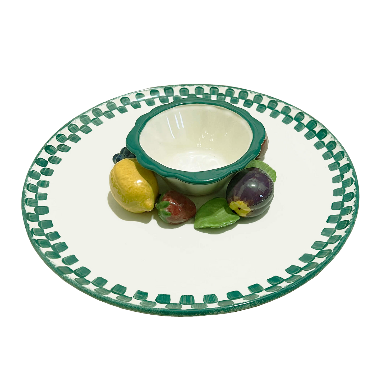 Ceramic plate with green rim and decorative edge, featuring a small bowl and fruit figurines on a white background.