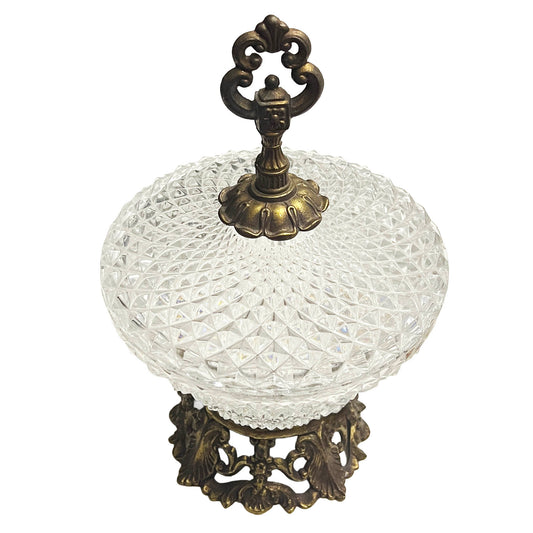Decorative glass bowl with a bronze lid and stand on a white background